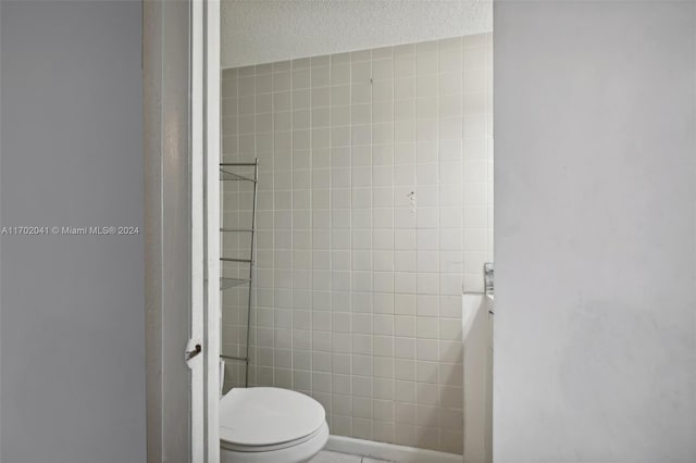 bathroom featuring a textured ceiling and toilet