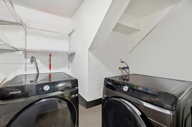 clothes washing area featuring washer and dryer and a textured ceiling