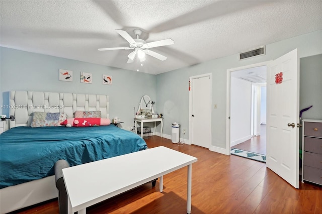 bedroom featuring ceiling fan, a textured ceiling, and hardwood / wood-style flooring