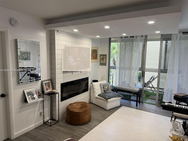 sitting room with a large fireplace and hardwood / wood-style floors