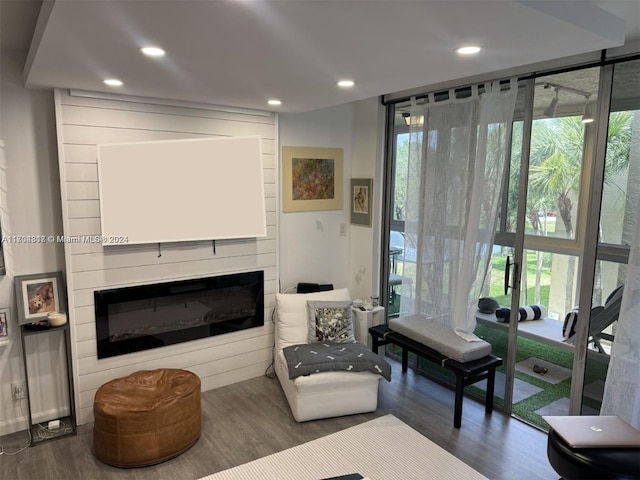 living room featuring dark hardwood / wood-style floors, a large fireplace, and floor to ceiling windows