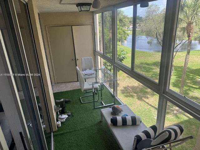 sunroom featuring a water view and a healthy amount of sunlight