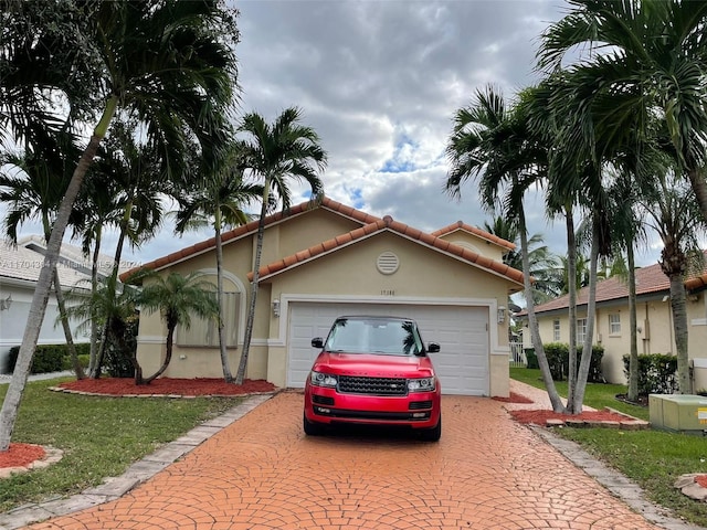 mediterranean / spanish house with a garage and a front lawn