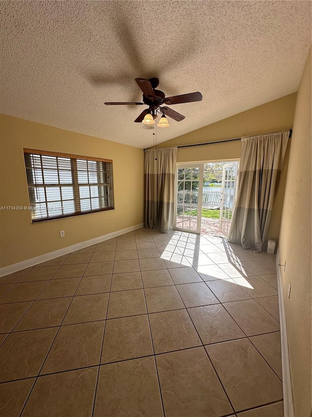 spare room with a textured ceiling, tile patterned floors, and ceiling fan