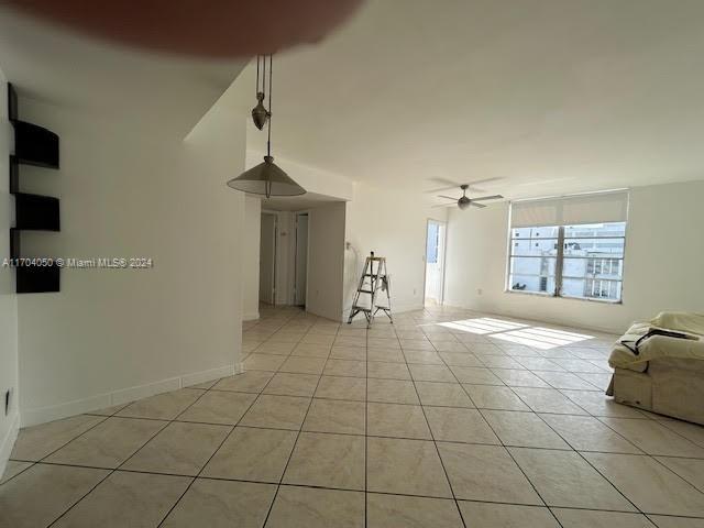 unfurnished living room featuring ceiling fan and light tile patterned floors