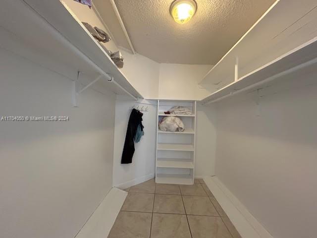 walk in closet with light tile patterned floors