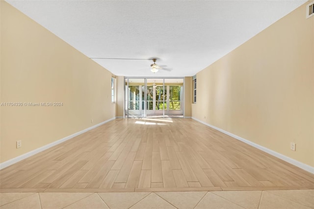 spare room with a textured ceiling, light hardwood / wood-style floors, and ceiling fan