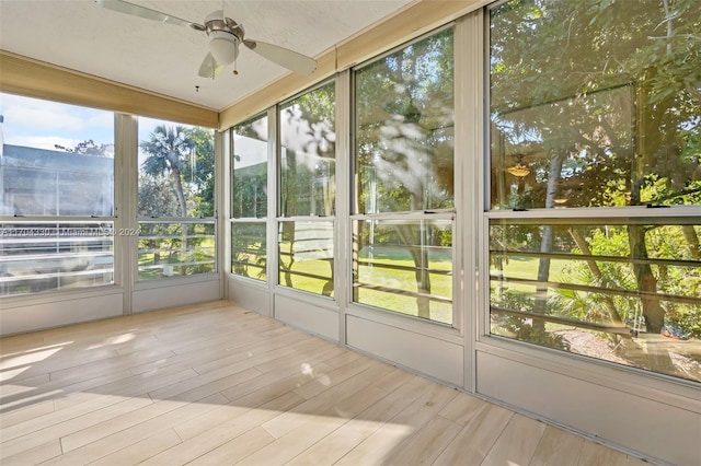 unfurnished sunroom with ceiling fan