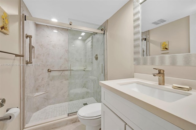 bathroom featuring vanity, an enclosed shower, and toilet