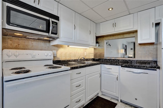 kitchen featuring a drop ceiling, white appliances, backsplash, white cabinets, and sink