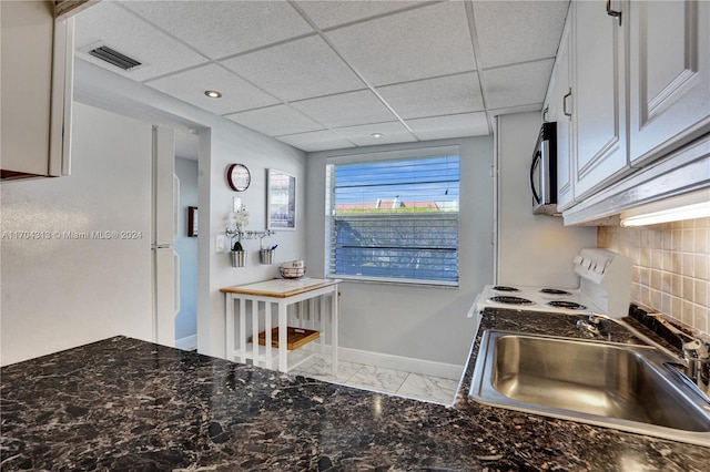 kitchen with white range with electric stovetop, a paneled ceiling, sink, and white cabinets