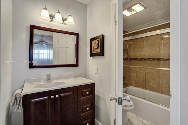 full bathroom featuring vanity, shower / bath combination with glass door, ceiling fan, toilet, and a textured ceiling