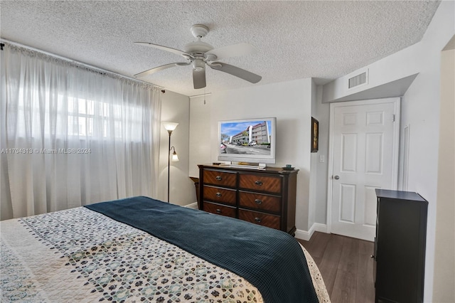 bedroom with a textured ceiling, dark hardwood / wood-style flooring, a closet, and ceiling fan