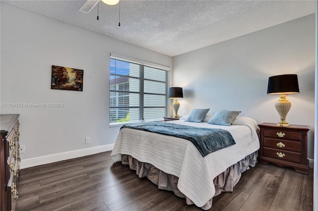 bedroom featuring ceiling fan, dark wood-type flooring, and a textured ceiling