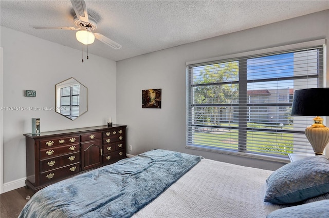 bedroom with ceiling fan, wood-type flooring, and a textured ceiling