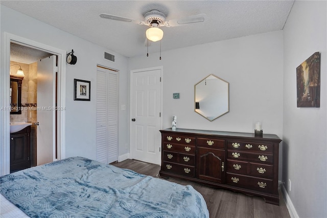 bedroom featuring ceiling fan, dark hardwood / wood-style flooring, ensuite bathroom, and a textured ceiling