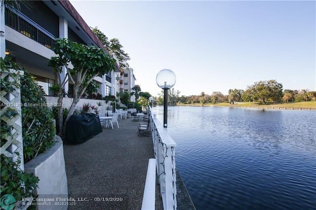 view of dock featuring a water view and a patio