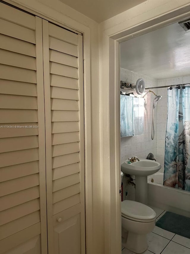 bathroom with tile patterned flooring, toilet, and shower / tub combo with curtain