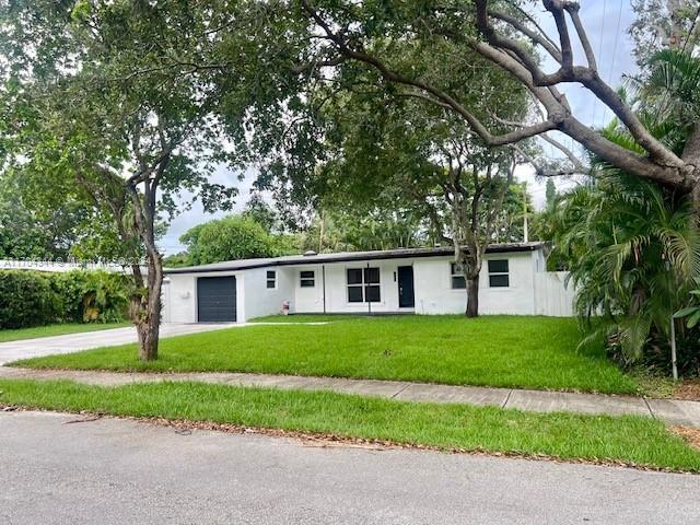 ranch-style house with a garage and a front lawn