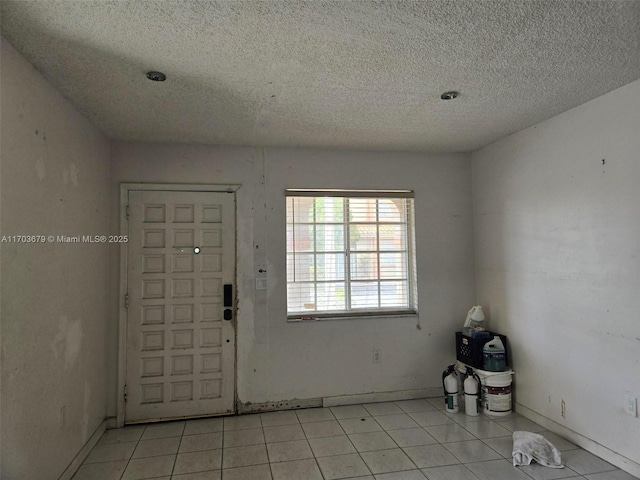 tiled foyer entrance with a textured ceiling