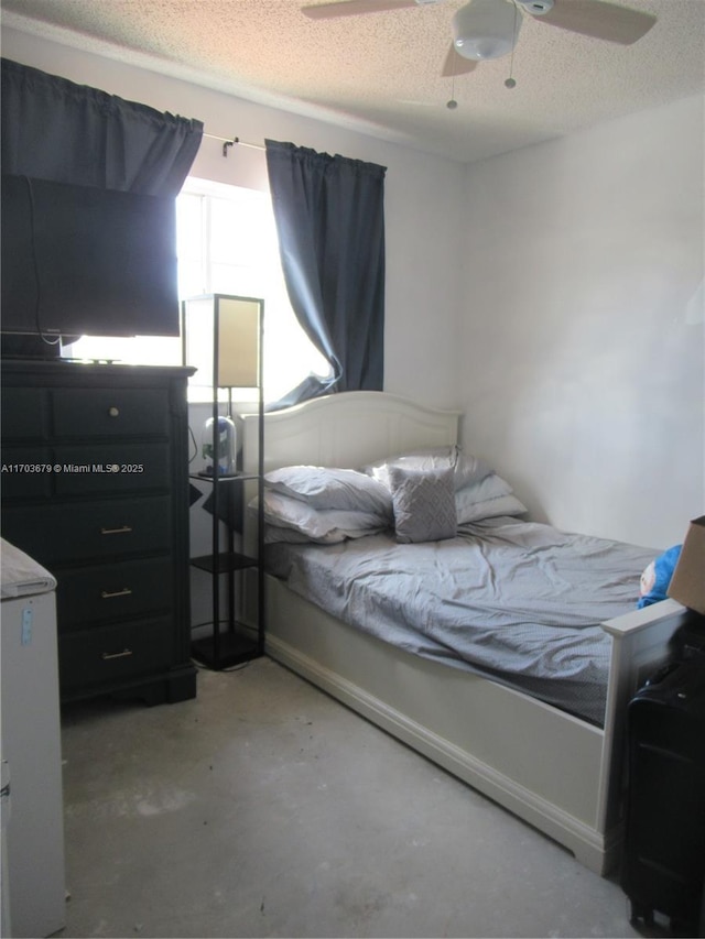 bedroom featuring ceiling fan, concrete flooring, and a textured ceiling