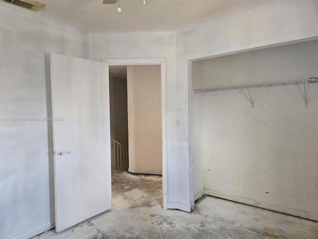 unfurnished bedroom featuring a textured ceiling, a closet, and ceiling fan