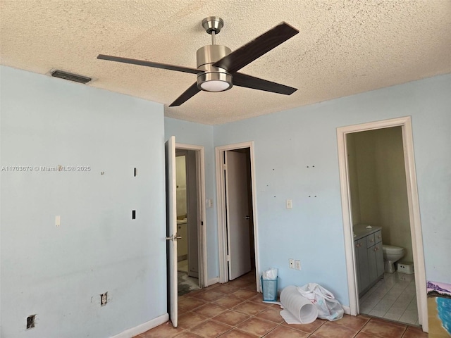 tiled bedroom featuring a textured ceiling, ensuite bathroom, and ceiling fan