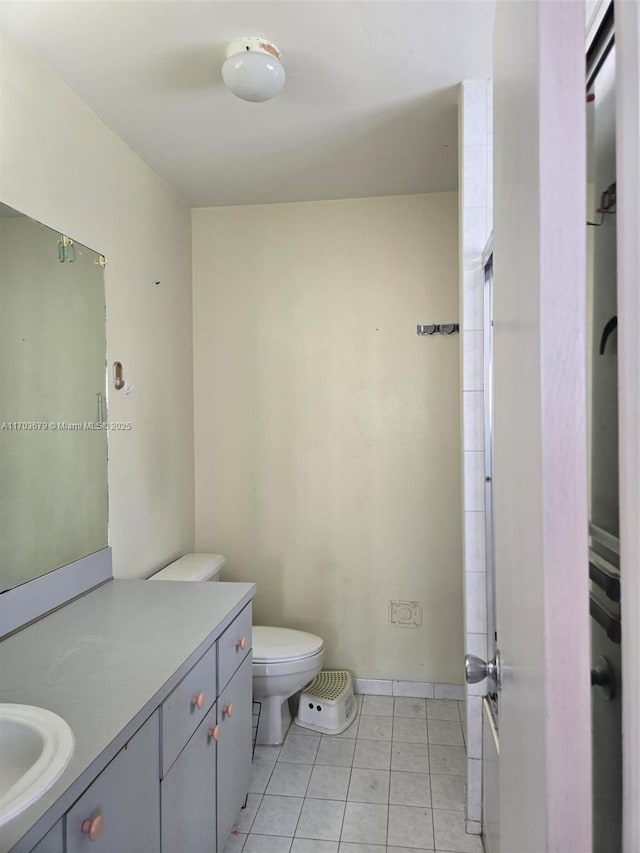 bathroom with tile patterned flooring, vanity, and toilet