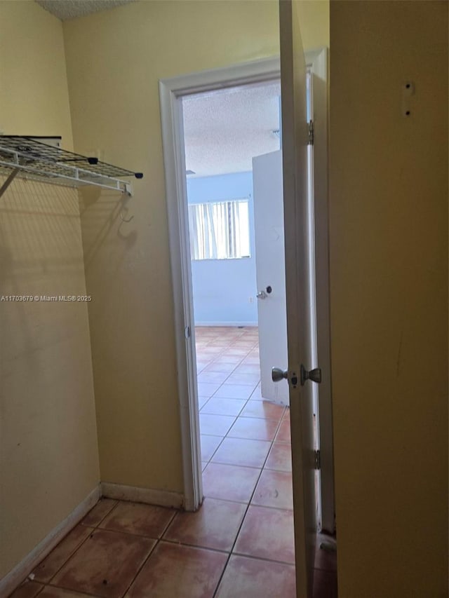 walk in closet with tile patterned floors