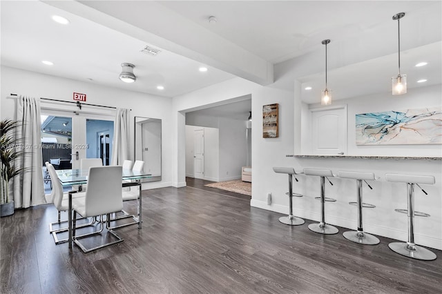 dining room featuring beamed ceiling and dark hardwood / wood-style flooring