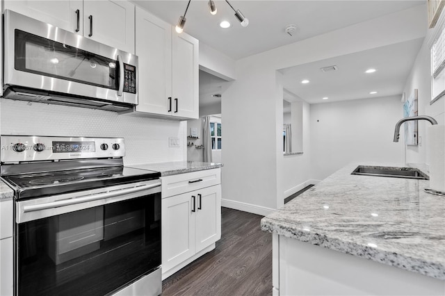 kitchen featuring white cabinetry, sink, light stone countertops, and appliances with stainless steel finishes