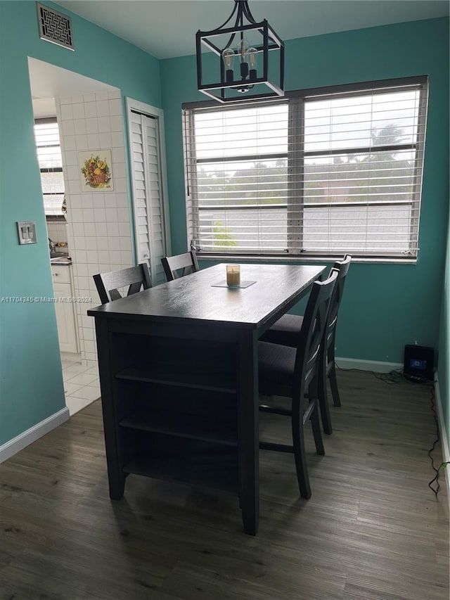 dining room with hardwood / wood-style floors and a notable chandelier