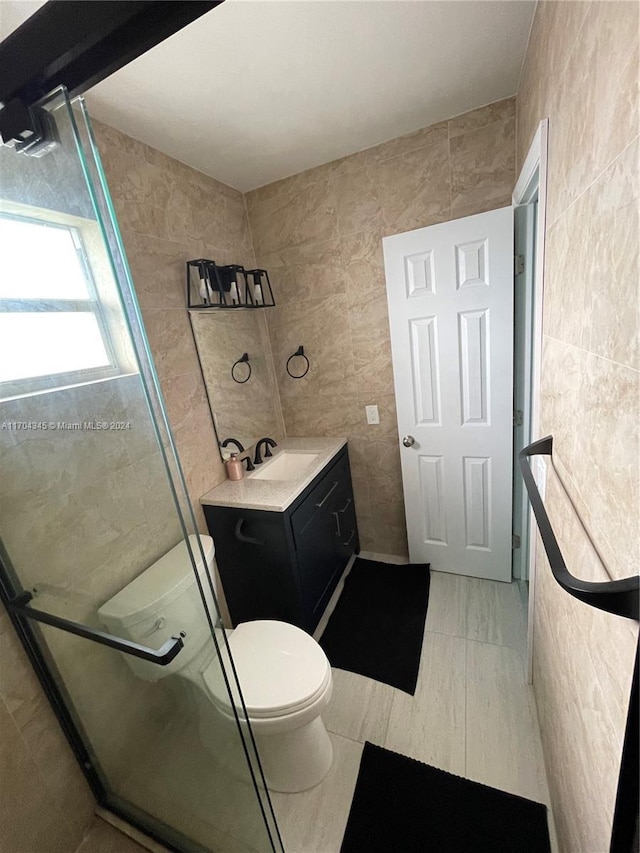 bathroom featuring vanity, tile walls, and a shower with shower door