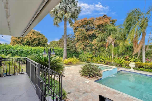 view of swimming pool with an in ground hot tub