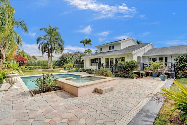 view of swimming pool with a patio and an in ground hot tub