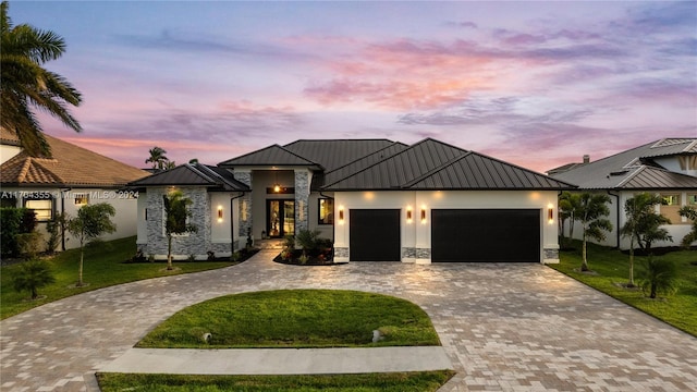 view of front of house featuring a garage and a lawn