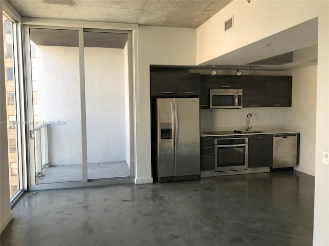 kitchen featuring floor to ceiling windows, sink, and stainless steel appliances