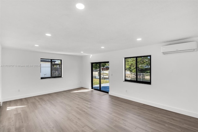 empty room with hardwood / wood-style floors and a wall mounted air conditioner