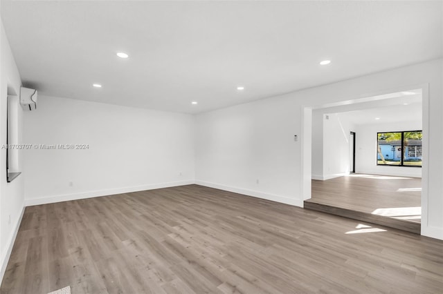 spare room with a wall unit AC and light wood-type flooring