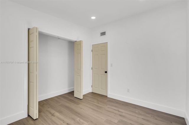 unfurnished bedroom featuring a closet and light hardwood / wood-style flooring