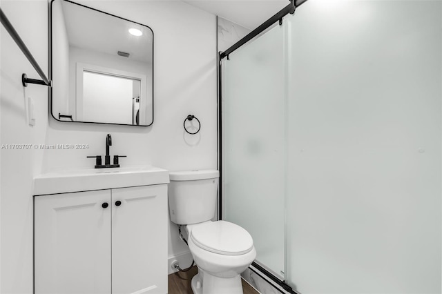 bathroom with vanity, wood-type flooring, an enclosed shower, and toilet