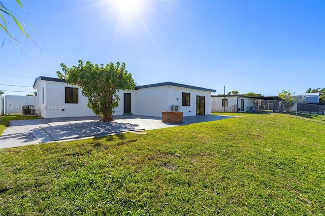 rear view of property featuring a lawn, a patio area, and central air condition unit