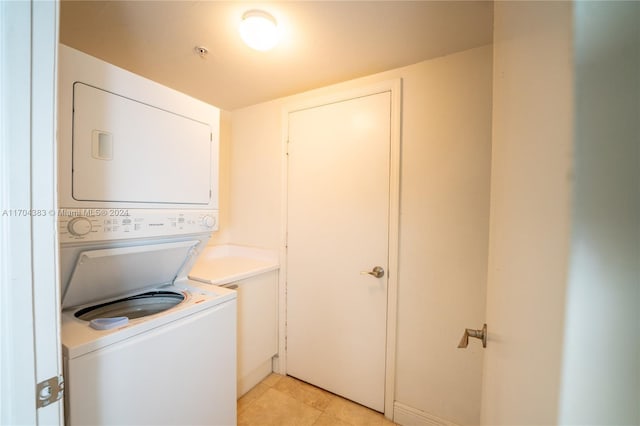 washroom featuring light tile patterned floors and stacked washer / dryer