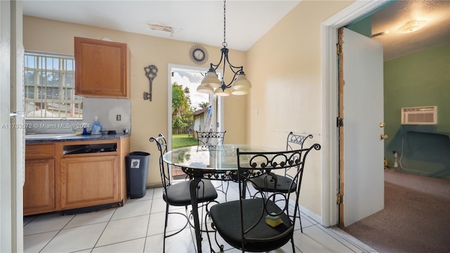 tiled dining room with an AC wall unit, sink, and a chandelier