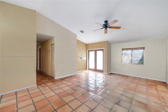 unfurnished room featuring ceiling fan, french doors, light tile patterned floors, and lofted ceiling