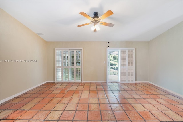 tiled spare room with ceiling fan