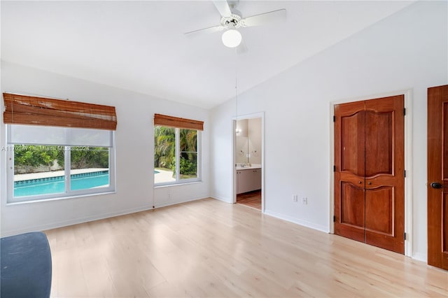 empty room featuring ceiling fan, light hardwood / wood-style flooring, and vaulted ceiling