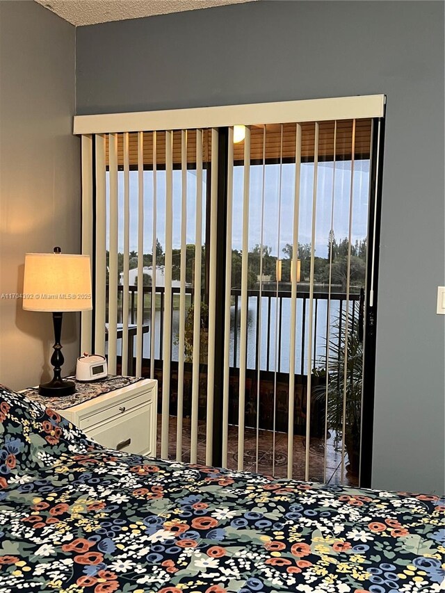 unfurnished bedroom with a water view and a textured ceiling