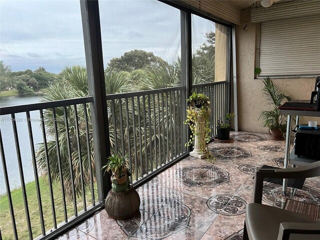 sunroom / solarium featuring a water view