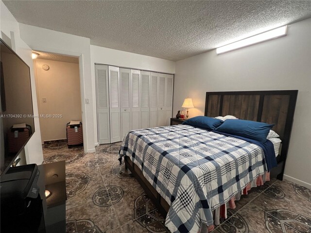 bedroom with a textured ceiling and a closet